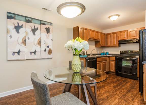 A kitchen with a table and chairs and a painting on the wall.