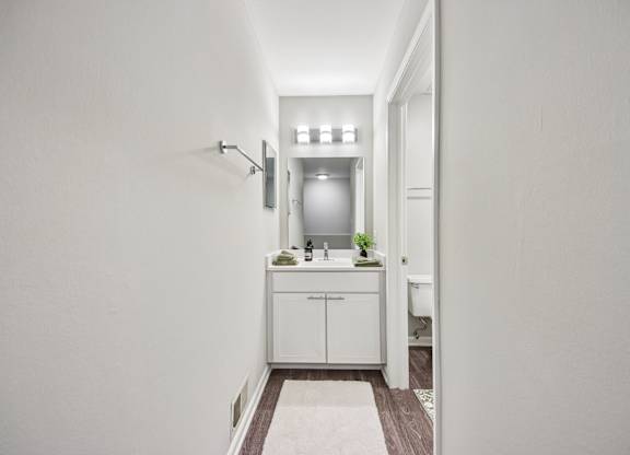 A white bathroom with a sink and a mirror.