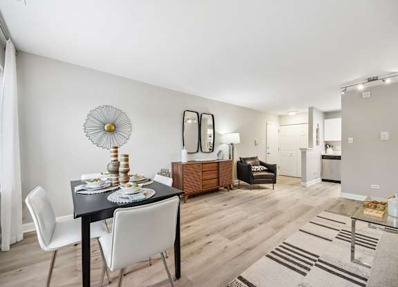 A dining room with a table set for two and a white chair.