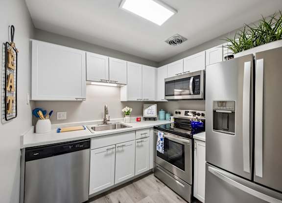 A modern kitchen with stainless steel appliances and white cabinets.