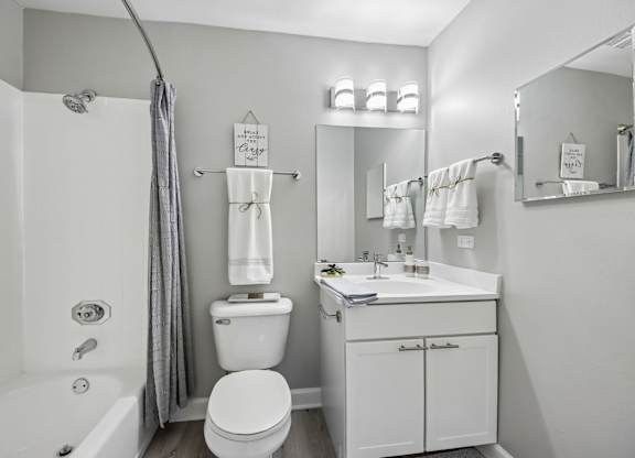 A white bathroom with a toilet, sink, and bathtub.
