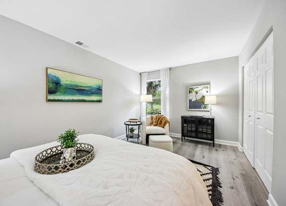 A bedroom with a large bed and a painting on the wall.