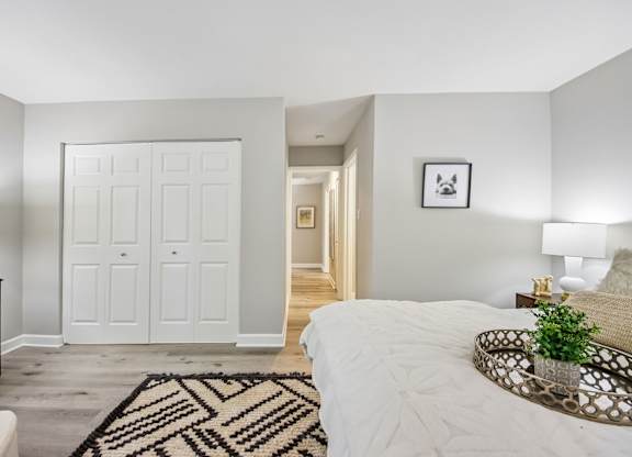 A bedroom with a large bed and a rug in the foreground.
