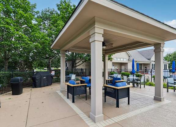 A covered outdoor seating area with tables and chairs.