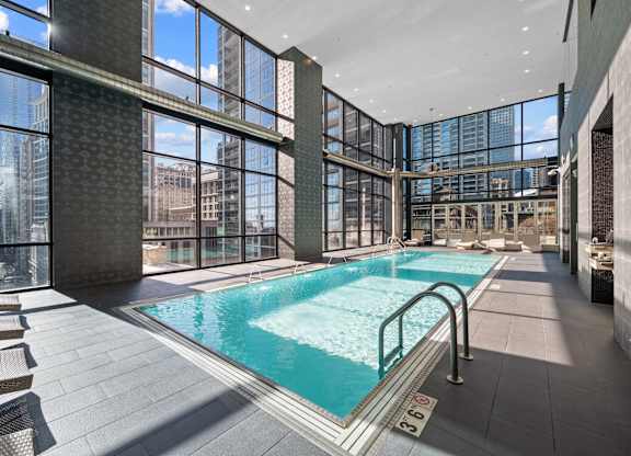 A large indoor swimming pool with a glass wall.