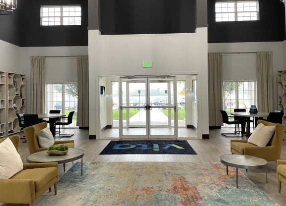 a large lobby with couches and chairs and a door to a pool