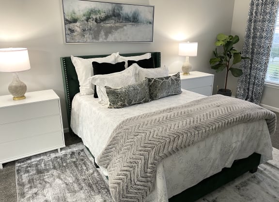 a gray and white bedroom with a bed and pillows