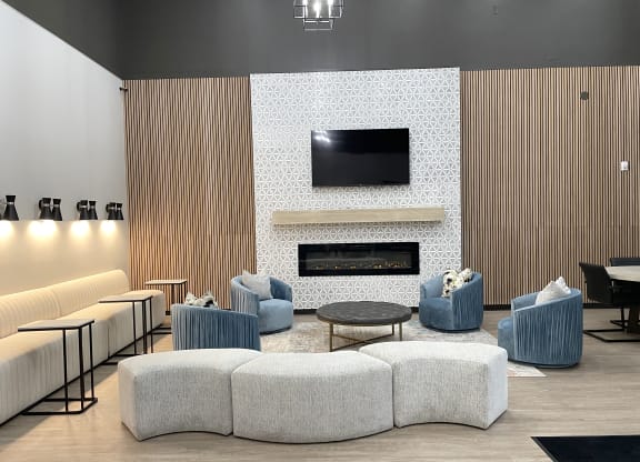 a living room with blue chairs and a fireplace