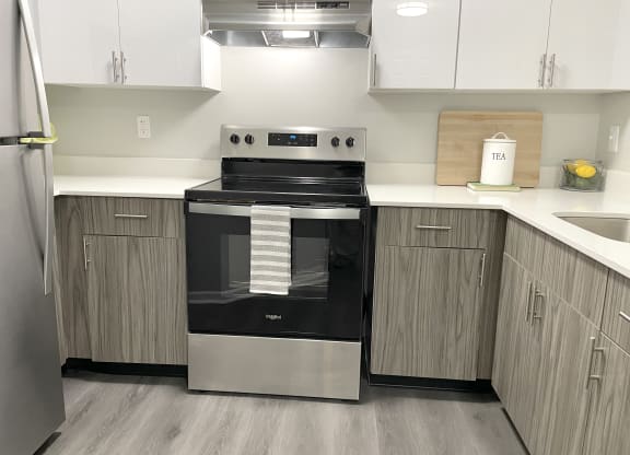 a kitchen with a stove and cabinets and a sink