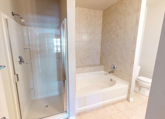 A bathroom with a white tub and toilet.