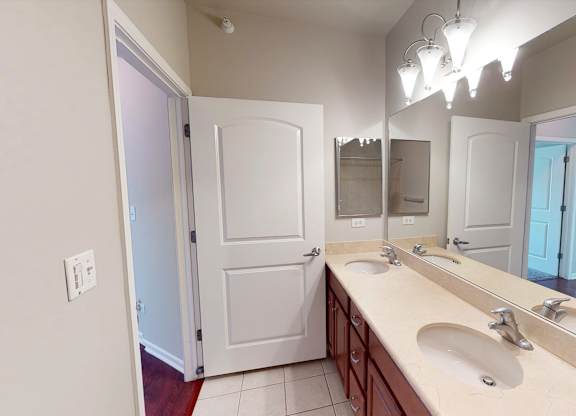 A bathroom with a white door, a sink, and a mirror.