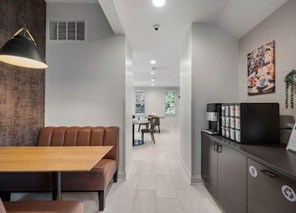 A modern dining area with a brown leather sofa and a wooden table.