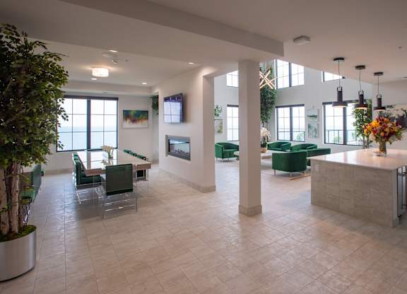 a large lobby with green furniture and a fireplace at 42 Hundred On The Lake, Wisconsin, 53235