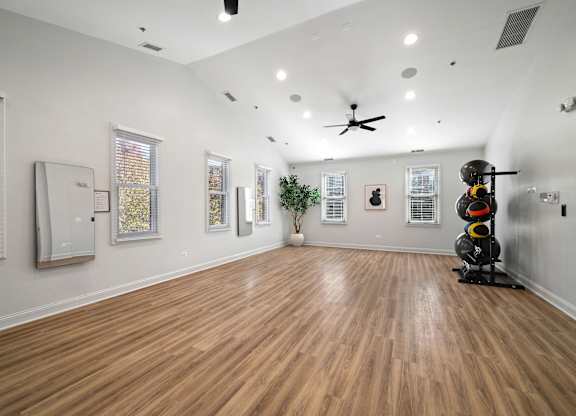 A room with wooden flooring and a ceiling fan.