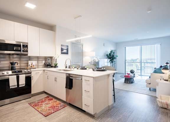 A modern kitchen with white cabinets and a large island. at Elevate Apartments, Madison, Wisconsin