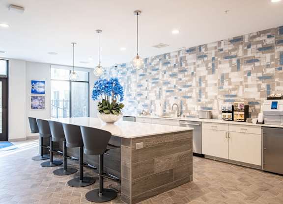 A kitchen with a long island and bar stools. at Elevate Apartments, Madison, Wisconsin