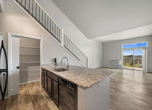 A kitchen with a granite countertop and wooden flooring.