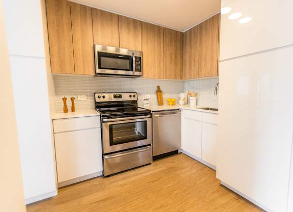 a kitchen with stainless steel appliances and white cabinets at The Kent, Chicago, IL, 60614