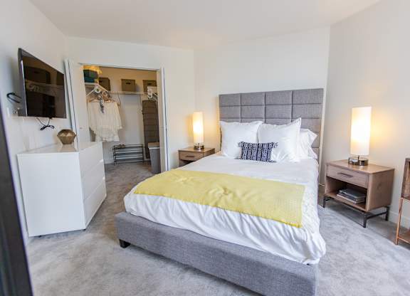 a bedroom with a bed and a closet and a mirror at The Kent, Chicago, Illinois