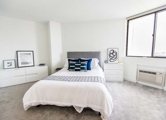 a bedroom with a bed and two windows at The Kent, Chicago