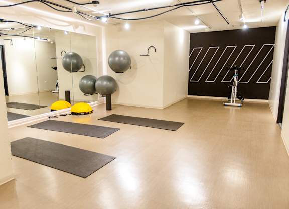 a fitness room with yoga mats and spheres on the floor at The Kent, Chicago