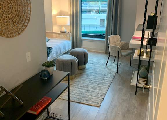 a living room with a bed and a sliding glass door at Residences at Addison Clark Apartments, Chicago, IL, 60613