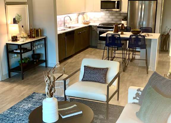 a living room and kitchen with a couch and a table  at Residences at Addison Clark Apartments, Chicago, 60613
