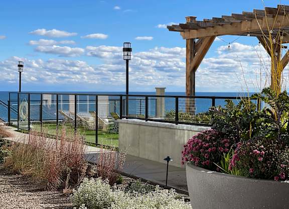 a view of the ocean from a garden with a pergola at 42 Hundred On The Lake, St Francis, WI, 53235