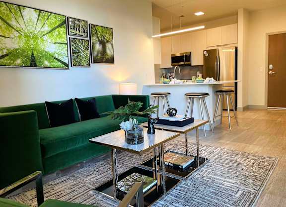 a living room with a kitchen in the background and a green couch at 42 Hundred On The Lake, St Francis, WI, 53235