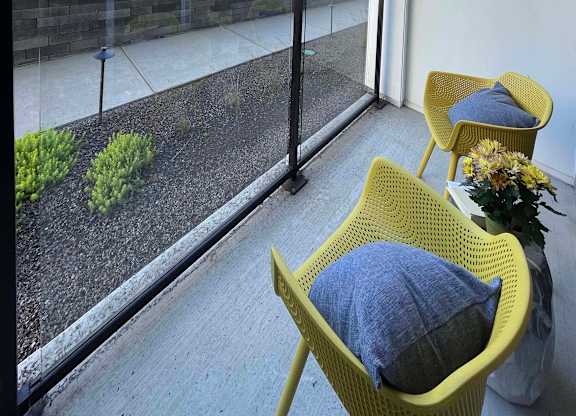 a small balcony with two chairs and a blue pillow at 42 Hundred On The Lake, St Francis
