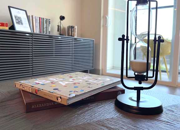 a table with a book and an hourglass on it at 42 Hundred On The Lake, St Francis, WI