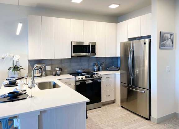 a kitchen with stainless steel appliances and white cabinets at 42 Hundred On The Lake, St Francis, 53235