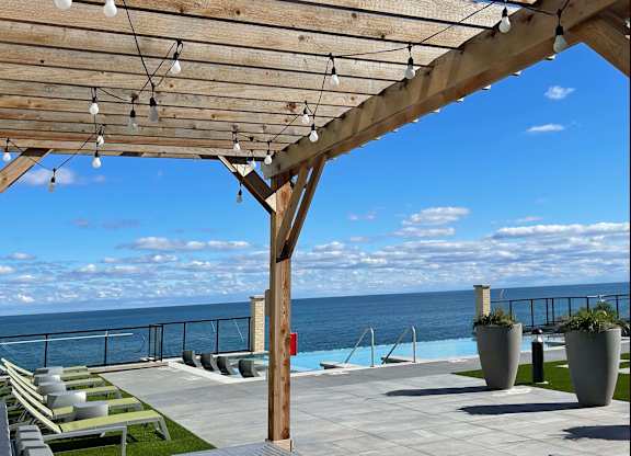 a view of  Lake Michigan from a patio with lounge chairs at 42 Hundred On The Lake, St Francis, 53235