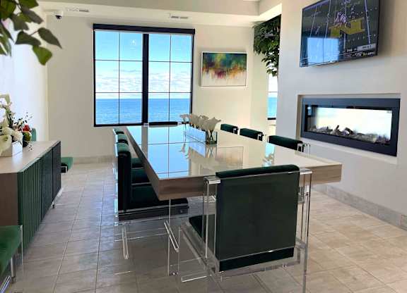a dining room with a glass table and chairs and a fireplace at 42 Hundred On The Lake, St Francis, WI