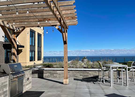 a patio with a grill and a pergola overlooking the ocean at 42 Hundred On The Lake, St Francis