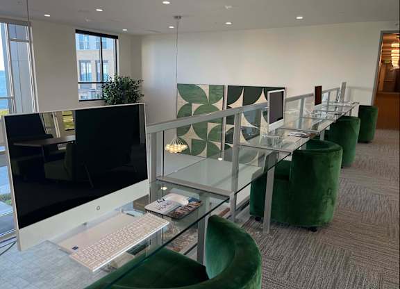 a modern office with green chairs and a glass desk with a laptop and a computer at 42 Hundred On The Lake, St Francis, WI, 53235