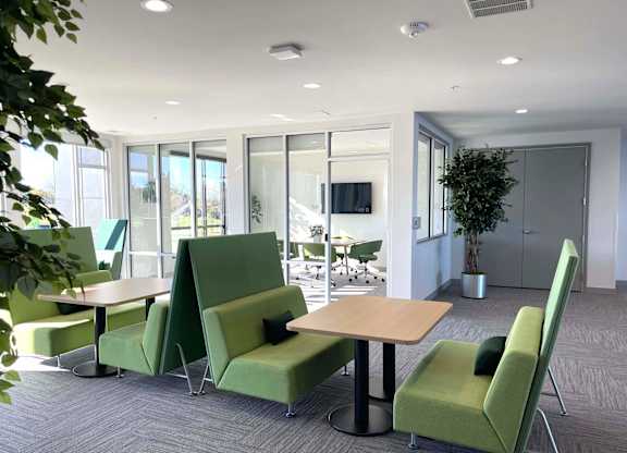 a lounge area with green chairs and tables at 42 Hundred On The Lake, Wisconsin, 53235