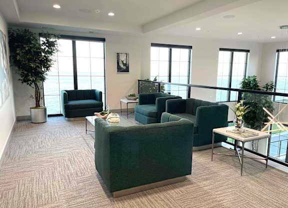 a living room with couches and chairs in front of windows at 42 Hundred On The Lake, Wisconsin, 53235