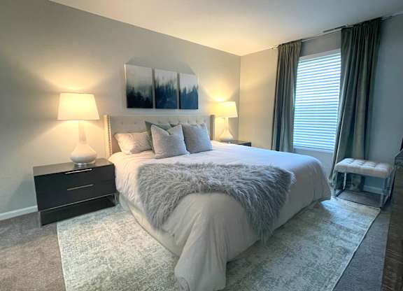 a bedroom with a large bed and a window at Evergreen Luxury Apartments, Merrillville