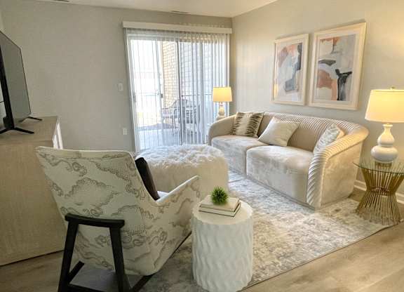 a living room with white furniture and a rug at Evergreen Luxury Apartments, Merrillville, 46410