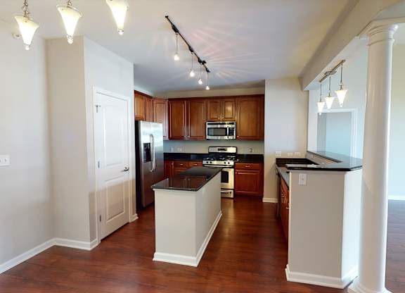 A kitchen with wooden cabinets and a black countertop.
