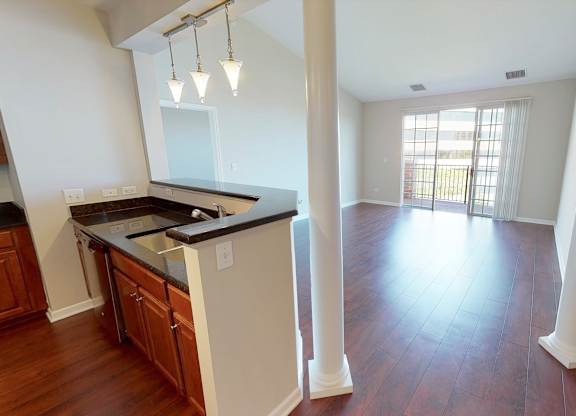 A kitchen with wooden floors and white walls.