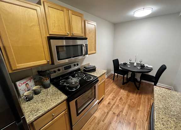 a kitchen and dining room with wood flooring and stainless steel appliances t Fieldpointe of Schaumburg, Illinois, 60173