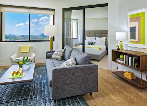a living room with a couch and a bed in a hotel room at The Kent, Chicago, 60614