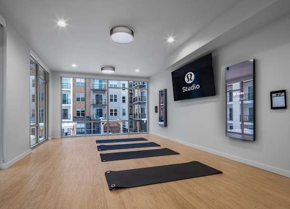 a yoga room with yoga mats on the floor and a large screen on the wall at 2929 on Mayfair, Wisconsin