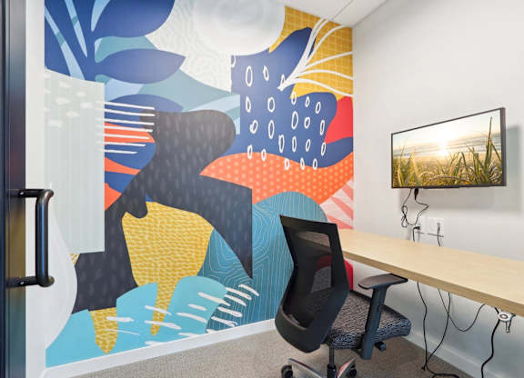 A modern office with a colorful mural on the wall.