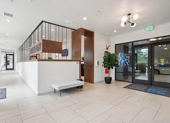 A reception area with a white reception desk and a bench.