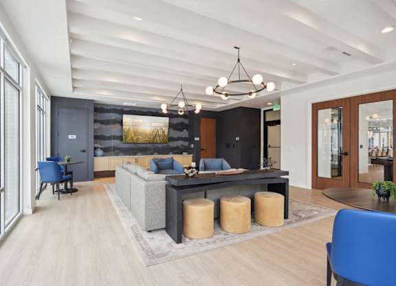 A modern living room with a blue chair and a grey sofa.