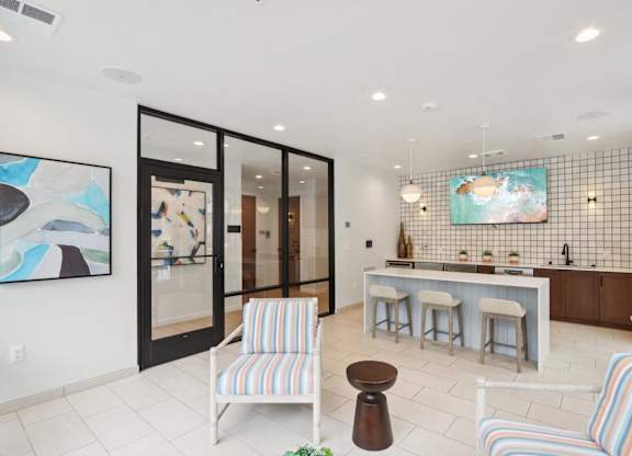 A kitchen with a bar and striped chairs.