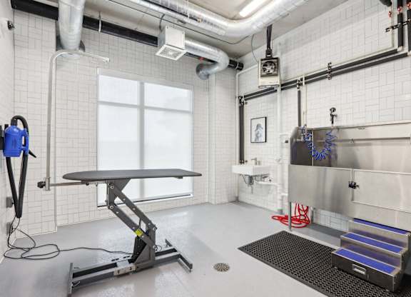 A clean, white room with a table, a vacuum cleaner, and a sink.